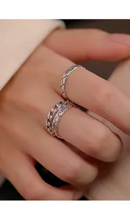 Macro view of retro Thai silver rings showing intricate lattice and chain patterns.