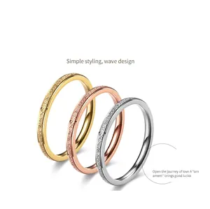 Detailed view of three frosted stainless steel rings in gold, silver, and rose gold.