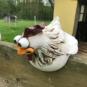 Close-up of a funny resin chicken head garden fence decoration with exaggerated large eyes