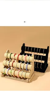 Close-up view of 3-tier linen and velvet jewelry display stands with various bracelets