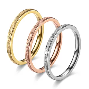 Close-up of three titanium steel frosted rings in gold, rose gold, and silver colors