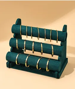 Elegant three-tier dark green velvet jewelry display stand for various golden bangles