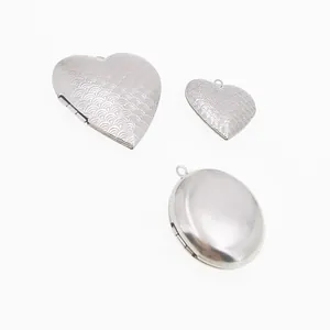 Detailed view of heart and oval stainless steel photo lockets with fine etched patterns