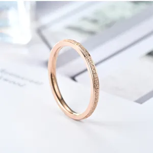 Detail view of women's minimalist rose gold titanium steel ring with frosted finish