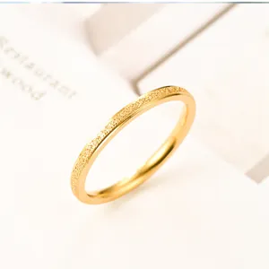 Close-up of minimalist titanium steel ring featuring a sophisticated gold frosted texture