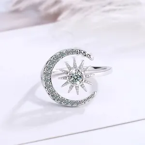 Detailed macro shot of a silver crescent moon and starburst ring with clear crystals