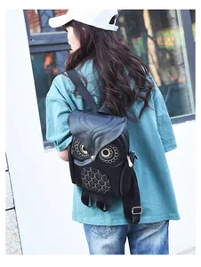 Detailed view of the stylish black 3D owl-shaped backpack worn by a model