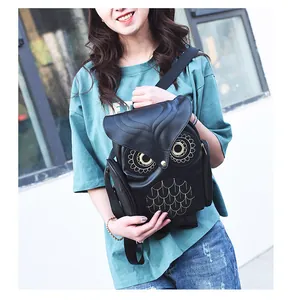Detailed shot of an owl-shaped black leather backpack worn by a female model outdoors.