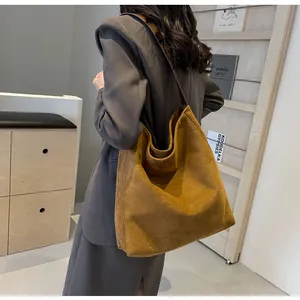 Nahaufnahme einer großen Tragetasche aus mattem Wildleder für einen schicken Büro-Look.