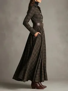Side view detail of a plaid maxi shirt dress with a leather belt and long sleeves