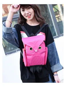 Detailed view of a cute pink owl-shaped backpack worn by an Asian model outdoors.