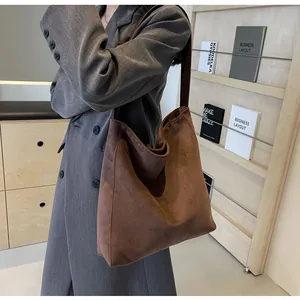 Seitenansicht einer großen braunen Vintage-Einkaufstasche kombiniert mit grauem Blazer.