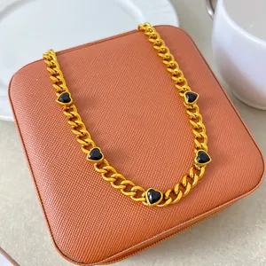 Gold plated titanium steel chain necklace featuring five black heart zircon accents