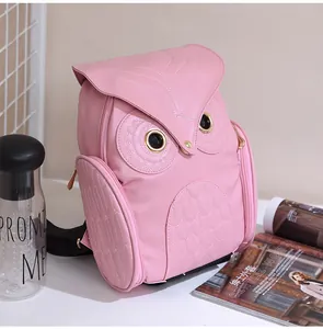 Close-up of pink 3D owl-shaped backpack featuring intricate stitching and golden zippers