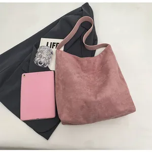 Detailansicht der rosa matten Wildleder-Einkaufstasche mit modischen Accessoires