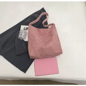 Rosa Shopper aus Wildlederimitat neben grauem Blazer und Tablet, ideal für das Büro.
