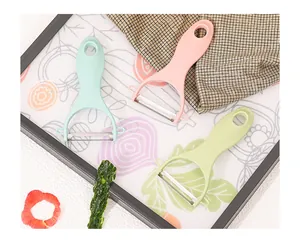 Three ergonomic Y-shaped vegetable and fruit peelers in pastel mint, pink, and lime