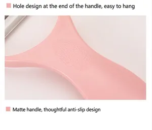 Close-up detail of a pink vegetable peeler handle with non-slip texture and hanging hole