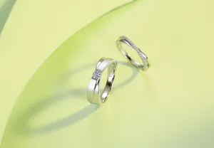 Detailed close-up view of silver X-shape pavé wedding bands with moissanite stones