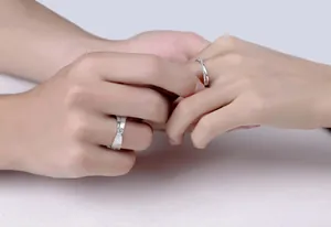 Close-up of S925 silver Moissanite couple wedding rings shown on hands for detail