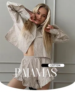 Detail einer Frau in einem beigen Gingham-Baumwoll-Pyjama-Set mit Rüschenshorts
