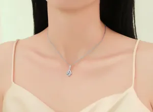 Close-up of a delicate mermaid tail pendant necklace with zircon on a female model