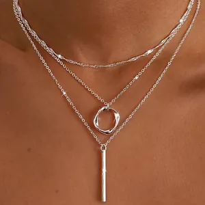 Detailed view of silver triple-layered necklace with circle and vertical bar pendants