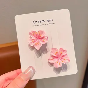 Close-up detail of two sweet pink cherry blossom hair clips attached to display card