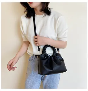 Sac à main en similicuir noir avec poignée froncée élégante et design plissé chic.