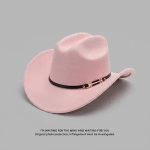 Detailed macro view of a pink felt cowboy hat featuring a black leather band and gold buckle.