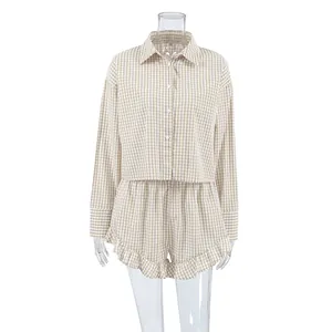 Detailansicht eines karierten Damen-Schlafanzugsets mit Langarmshirt und Rüschenshorts.