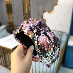 Stylish knotted headband with shimmering pink sequins for a trendy high cranial top look