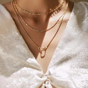 Detailed view of a three-layered 14K gold plated layered necklace on a model.