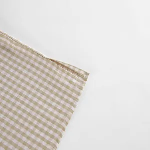 Detailansicht der Nähte und Textur des karierten Baumwoll-Schlafanzugstoffs