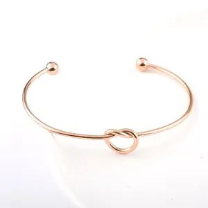 Elegant rose gold stainless steel open cuff bracelet with a minimalist knot design