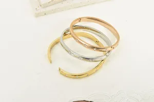Close-up of three 18K gold plated titanium steel bangles with star-shaped rhinestones