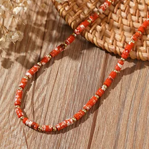 Vue détaillée d'un collier de style bohème avec perles en pierre marbrée rouge et or.