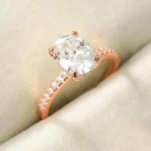 Close-up detail of elegant rose gold plated oval zircon ring with pavé set side stones