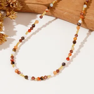 Gros plan sur les perles de pierres fines naturelles et intercalaires dorés du collier