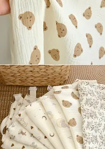 Detail view of soft breathable cotton muslin nursing covers with cute animal patterns.