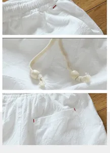 Close-up of white cotton linen shorts detailing the elastic waistband and beaded drawstrings