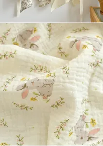 Close-up detail of soft quilted cotton nursing cover with cute bunny and floral print