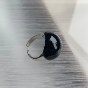 Detail showing the glossy black eggshell dome on a silver open adjustable ring