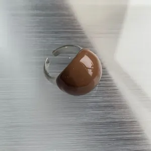 Detailed macro view of a glossy caramel brown enamel ring with a retro eggshell design