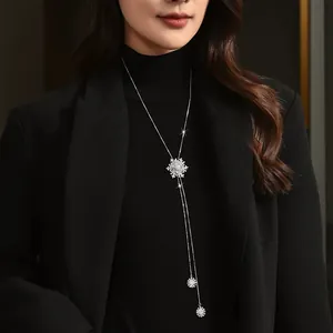 Elegant rotating snowflake long necklace for women, titanium steel jewelry on black sweater.