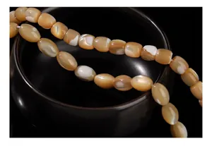 Macro detail view showing texture of natural golden and white oval shell beads