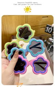 Detail shot of cute flower-shaped sunglasses for children in pink, blue, and yellow.