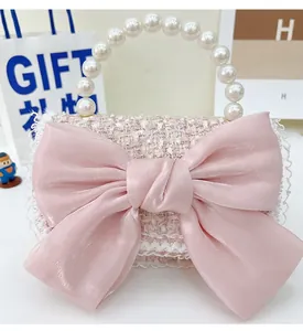 Vue détaillée d'un sac à main en tweed rose pour fille avec grand nœud et poignée de perles