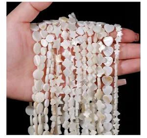 Detailed close-up of various shaped natural shell beads for DIY jewelry making.