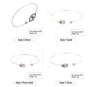 Detailed view of evil eye and hamsa hand bangles in gold, silver, and rose gold finish